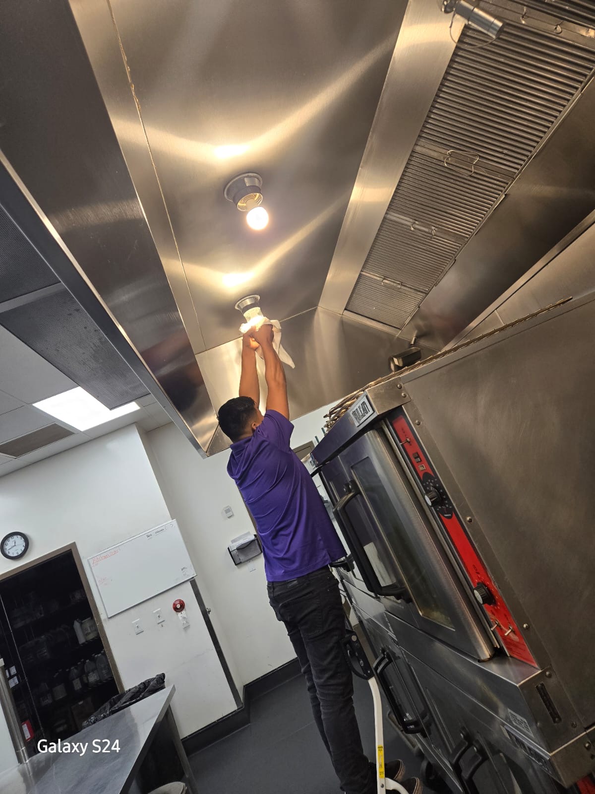 Us Cleaning Solutions team detailing a commercial kitchen hood and light fixtures in Scottsdale, Arizona
