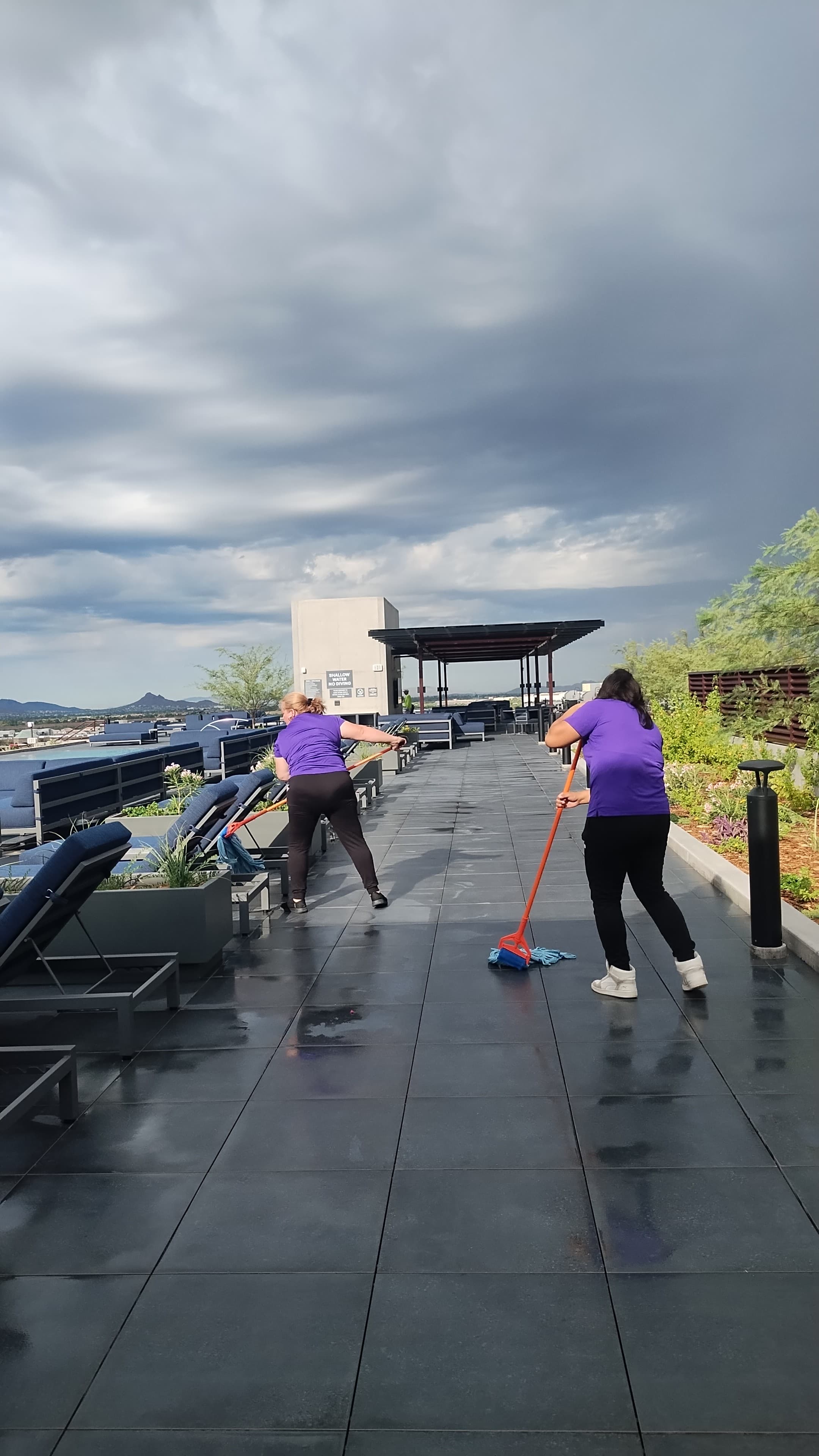 Us Cleaning Solutions team mopping a rooftop pool deck at a luxury high-rise community in Scottsdale, Arizona